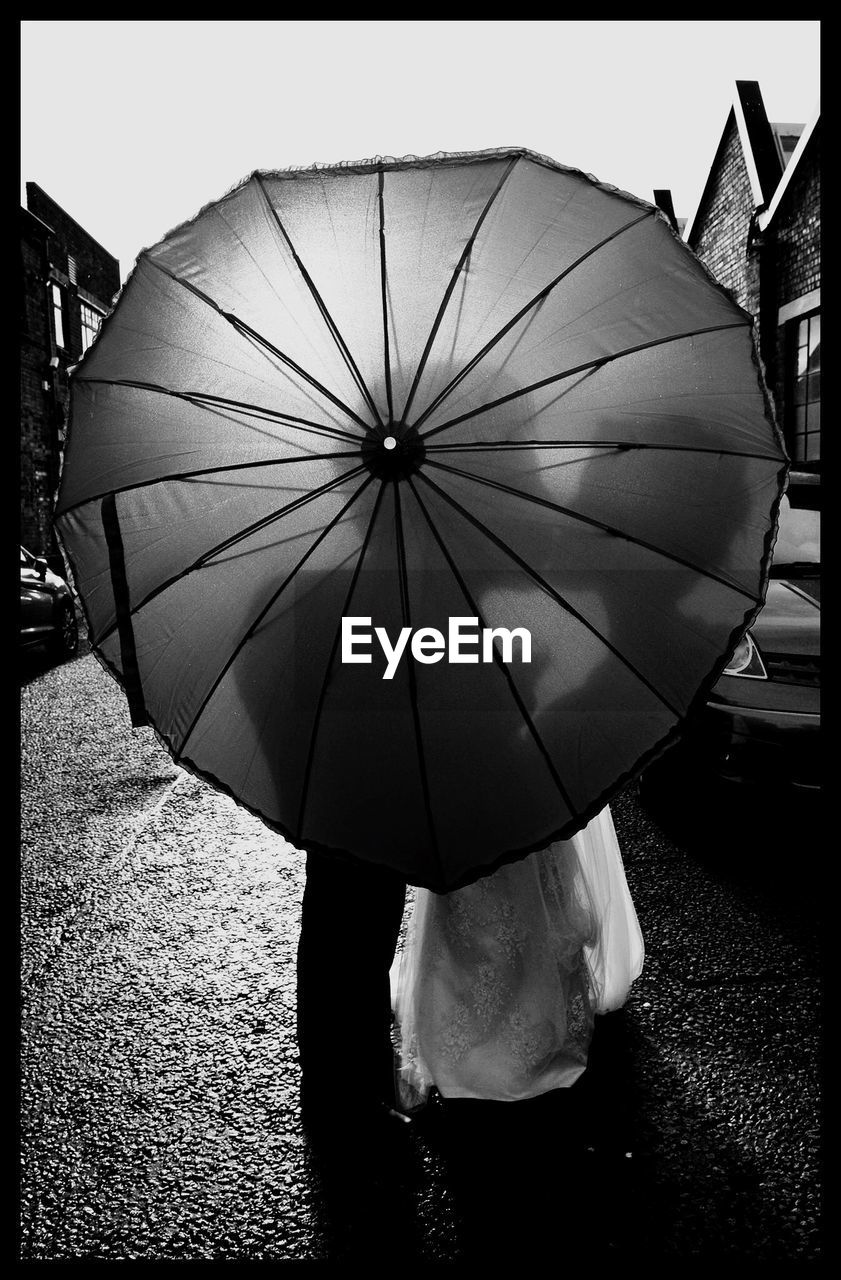 Shadow of couple kissing on umbrella