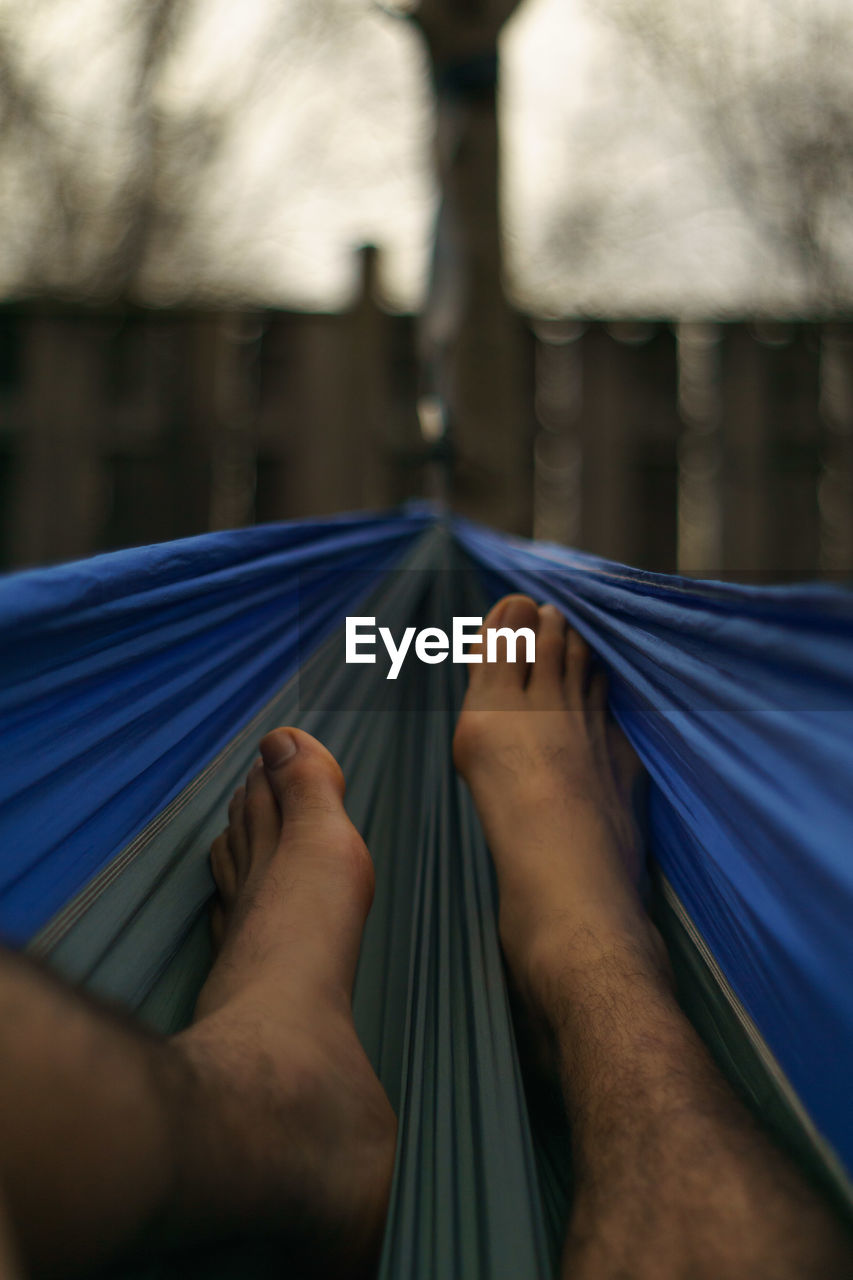 Low section of man resting on hammock
