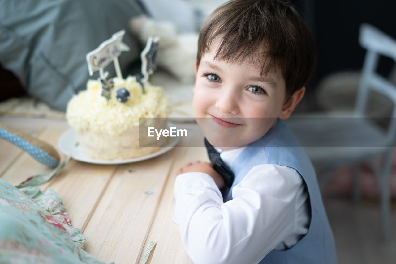 Portrait of cute boy with cake on table