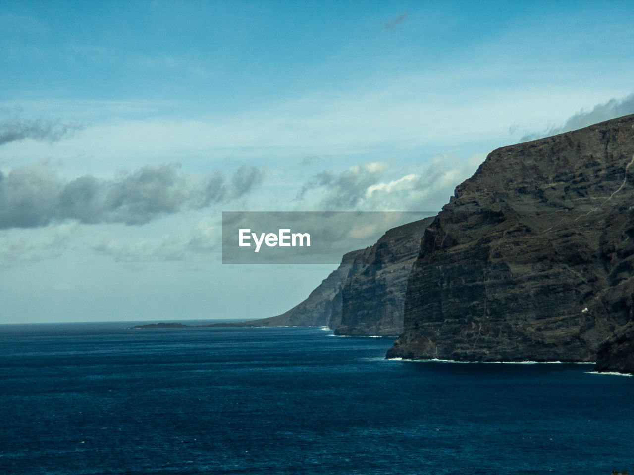 SCENIC VIEW OF SEA BY MOUNTAIN AGAINST SKY