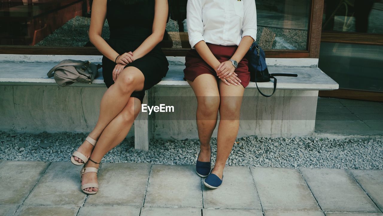 Low section of women sitting outdoors