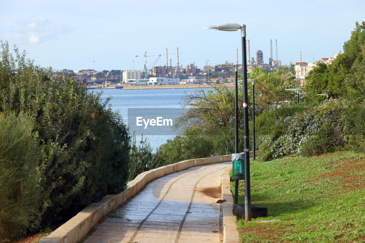 walkway, water, plant, sky, nature, architecture, waterway, tree, transportation, built structure, transport, boardwalk, no people, sea, city, coast, day, building exterior, travel destinations, outdoors, footpath, land, travel, street, vacation, street light, mode of transportation, nautical vessel, shore, body of water, beach, beauty in nature, pier, tourism, building, bridge, scenics - nature, tranquility