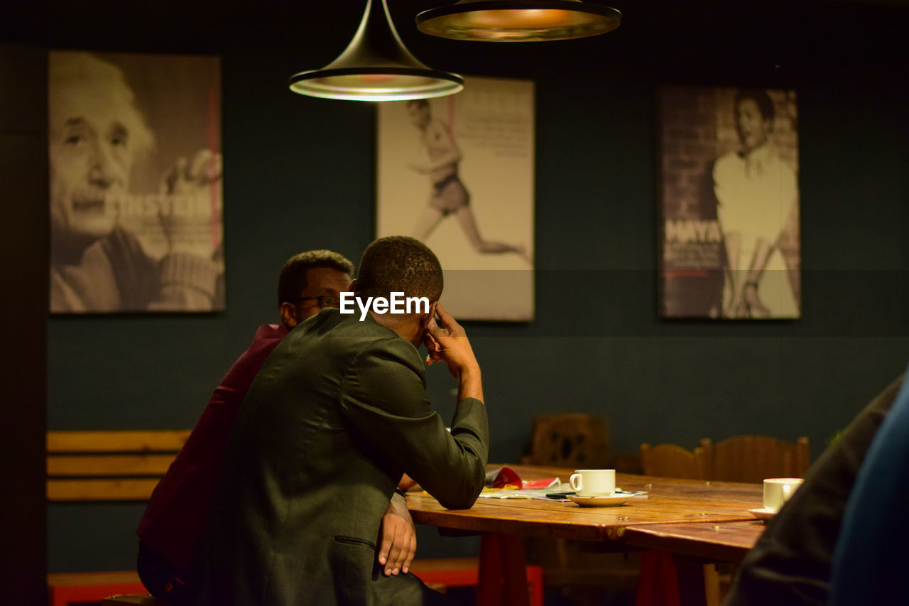 Side view of people sitting at table in restaurant