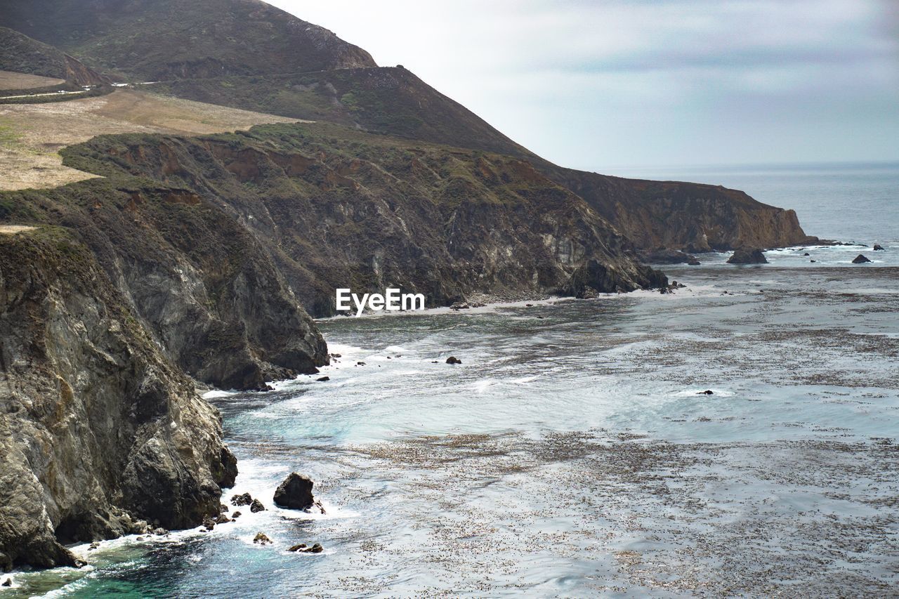 Scenic view of rocky beach against sky