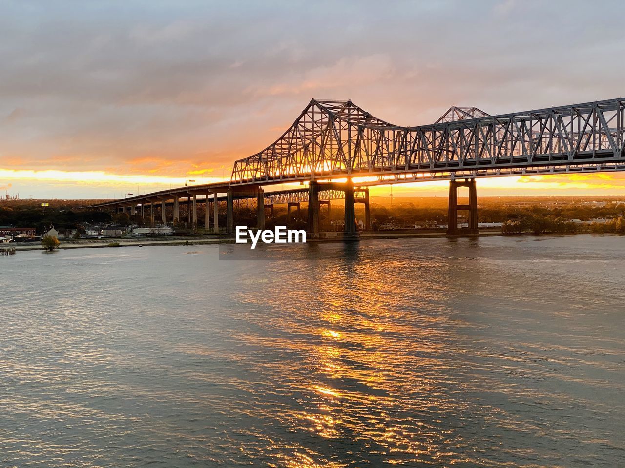 Bridge over river against sky during sunset