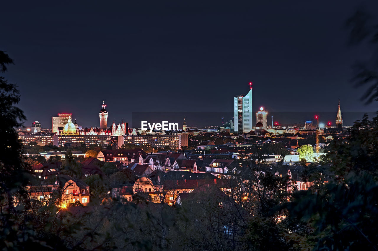 High angle view of illuminated buildings against sky at night