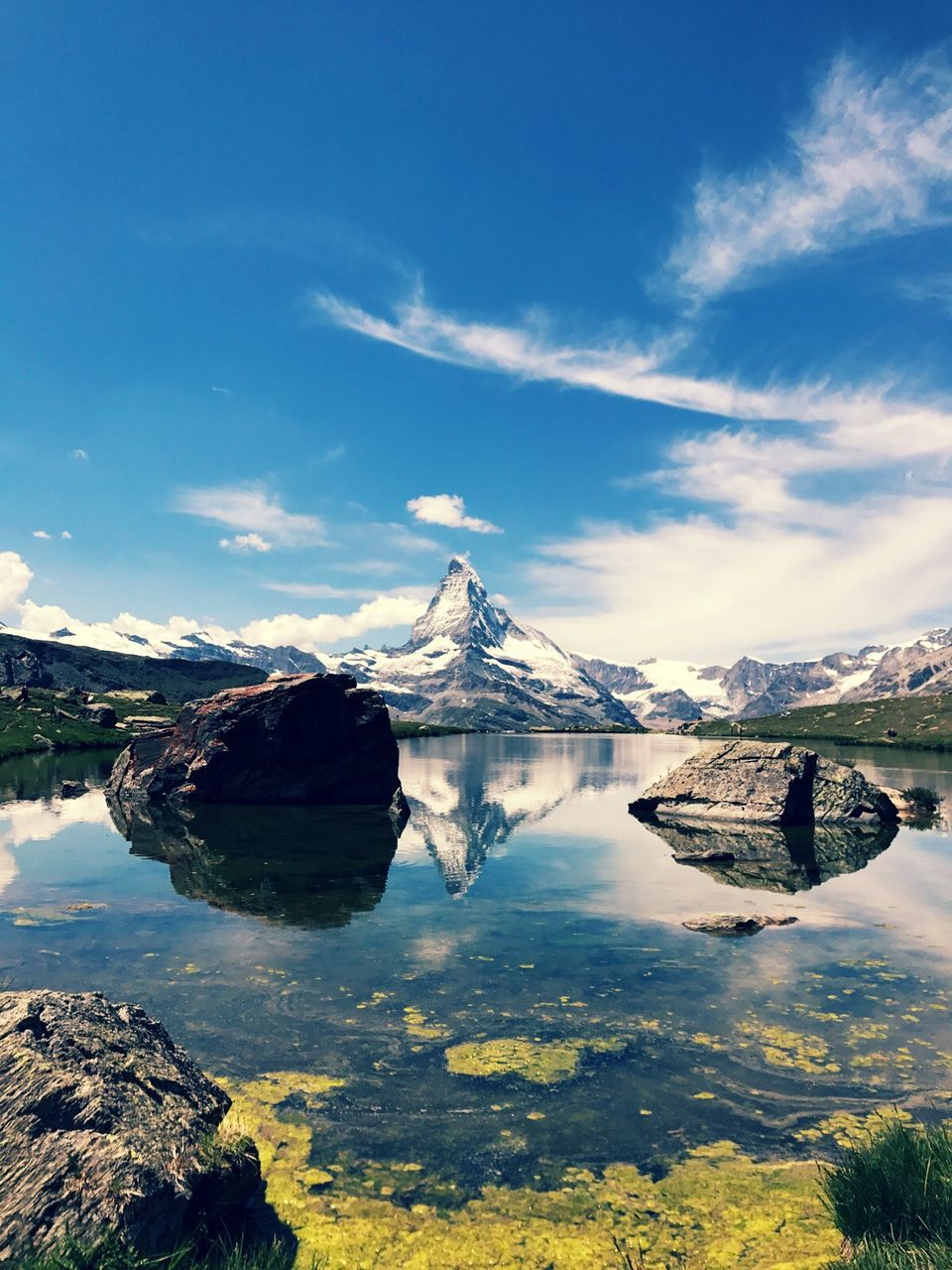 Scenic view of riffelsee lake by matterhorn mountain against sky