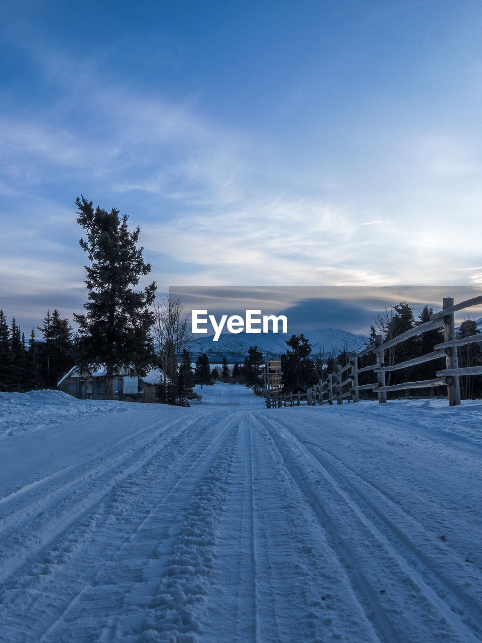 TIRE TRACKS ON SNOW COVERED ROAD