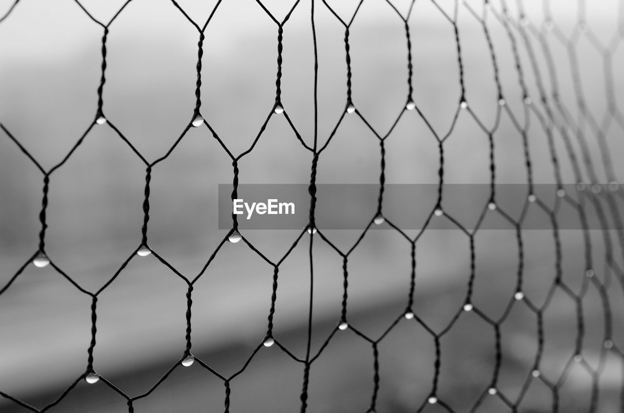 FULL FRAME SHOT OF SOCCER FIELD SEEN THROUGH FENCE