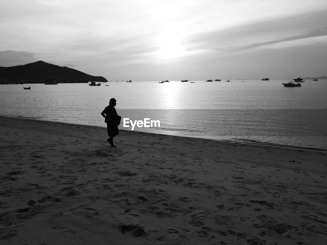 BOY ON BEACH AGAINST SKY DURING SUNSET