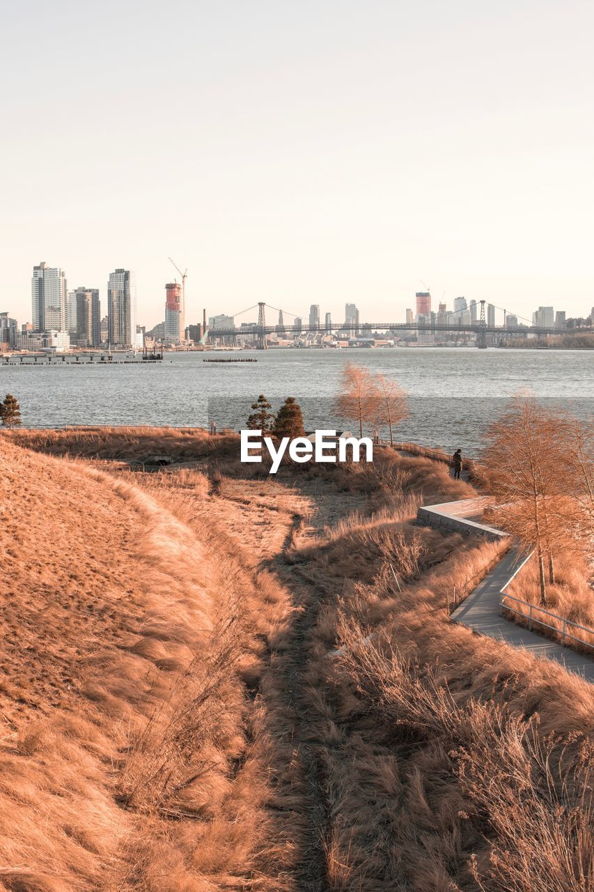 Scenic view of sea and buildings against clear sky