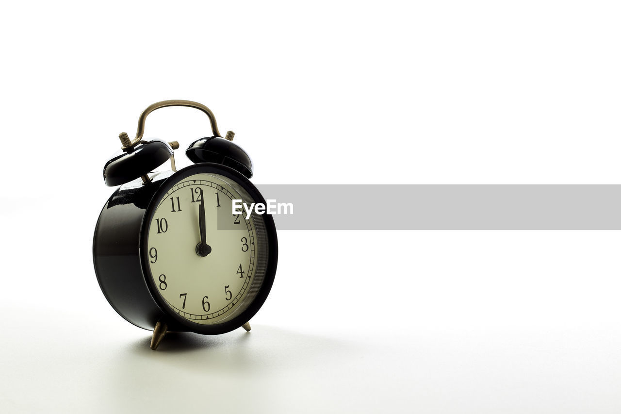 Close-up of alarm clock against white background