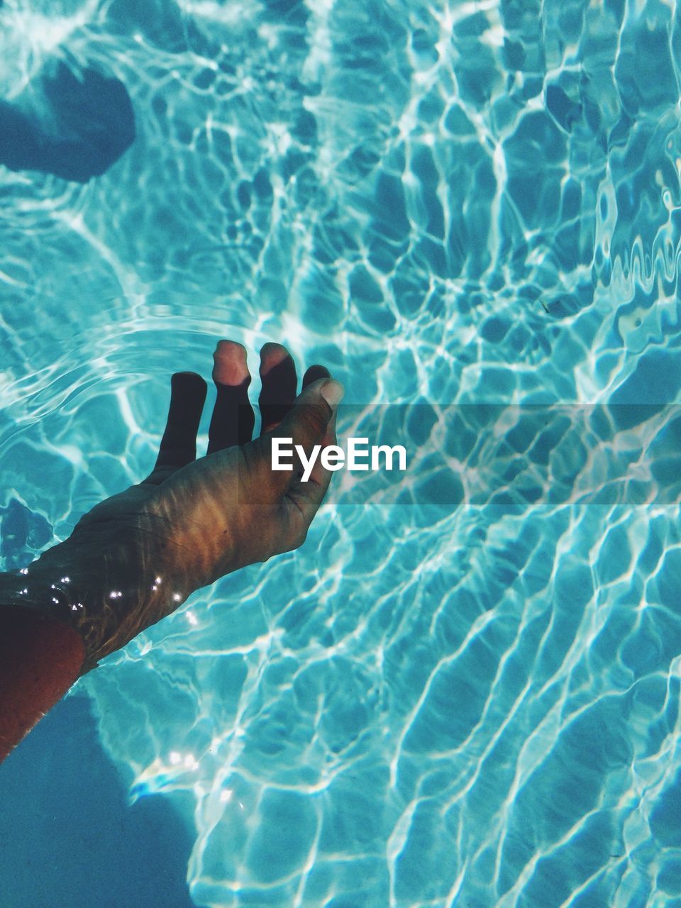 Cropped image of hand in swimming pool