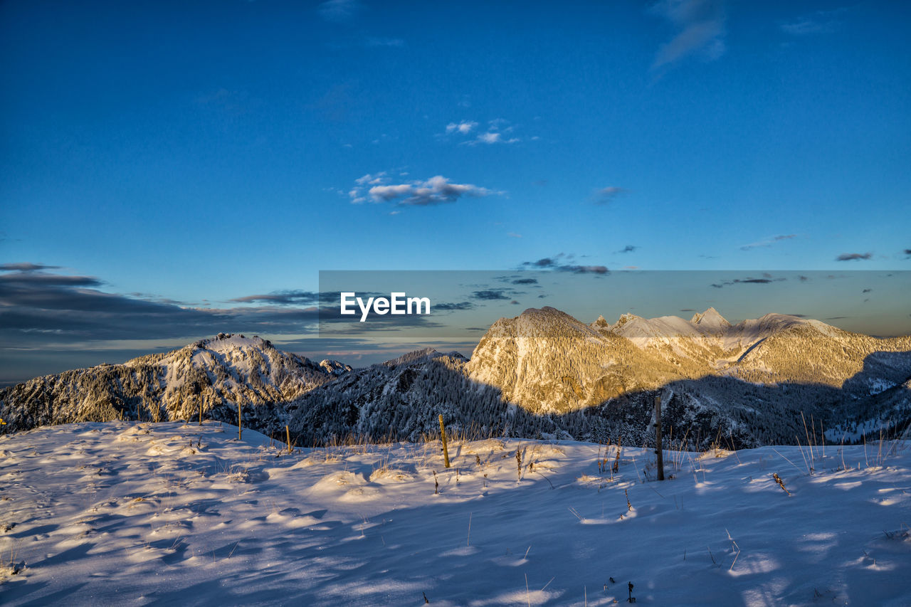 Scenic view of snowcapped mountains against blue sky