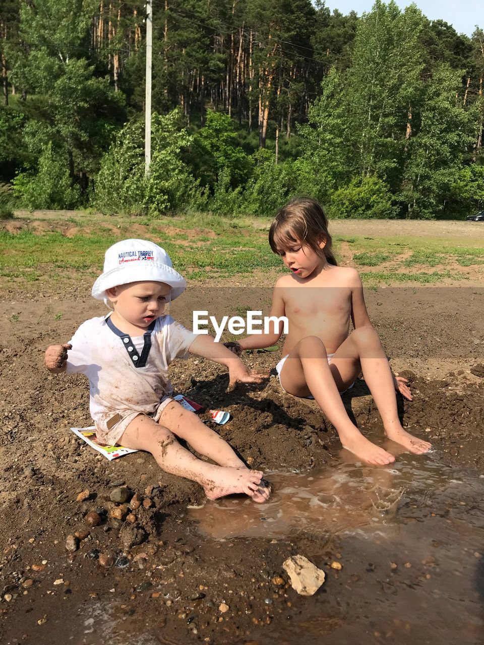 HAPPY SIBLINGS AND PLANTS AGAINST TREES AND PLANT