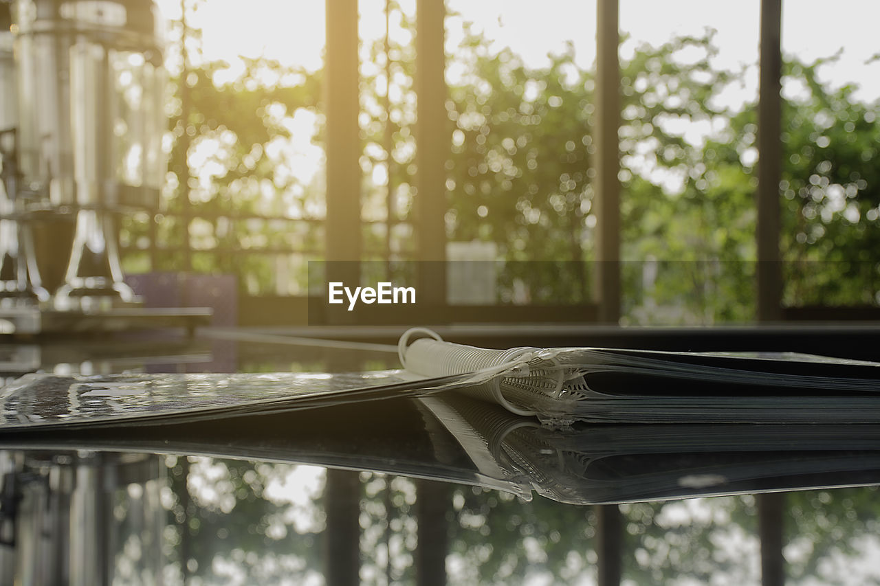 Close-up of menu on glass table with reflection at cafe