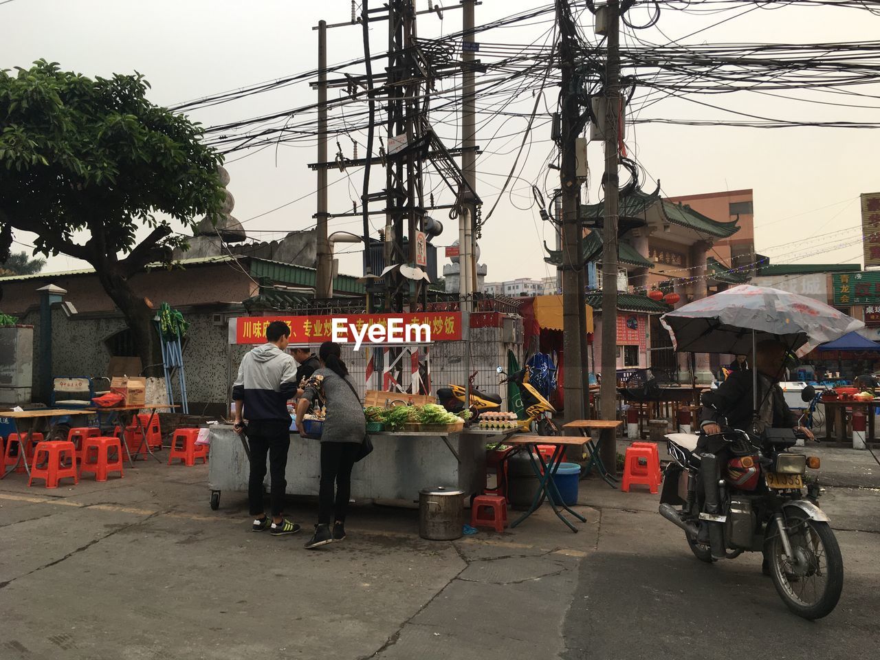 PEOPLE ON MOTORCYCLE IN CITY