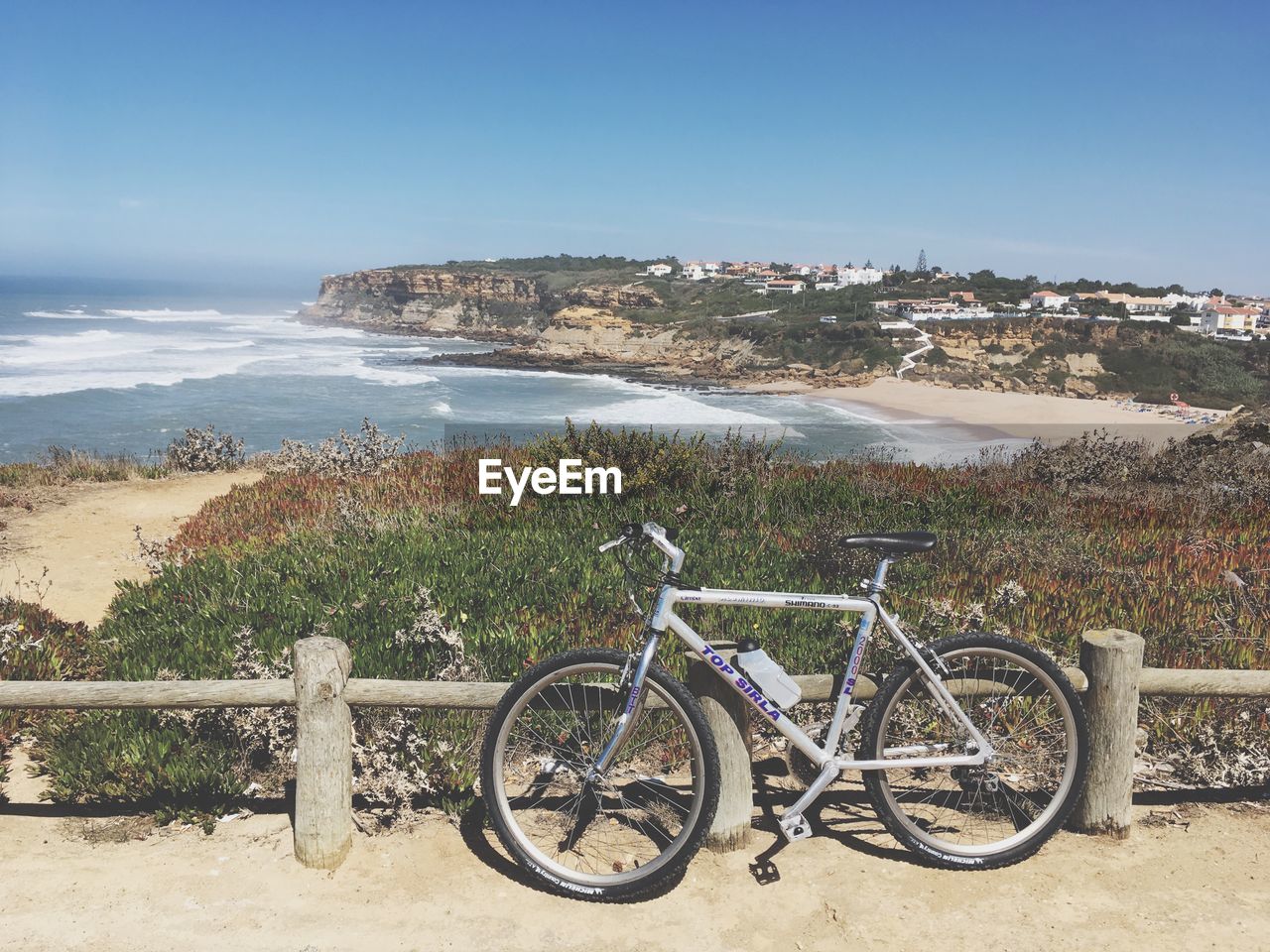 BICYCLES ON BEACH AGAINST SKY