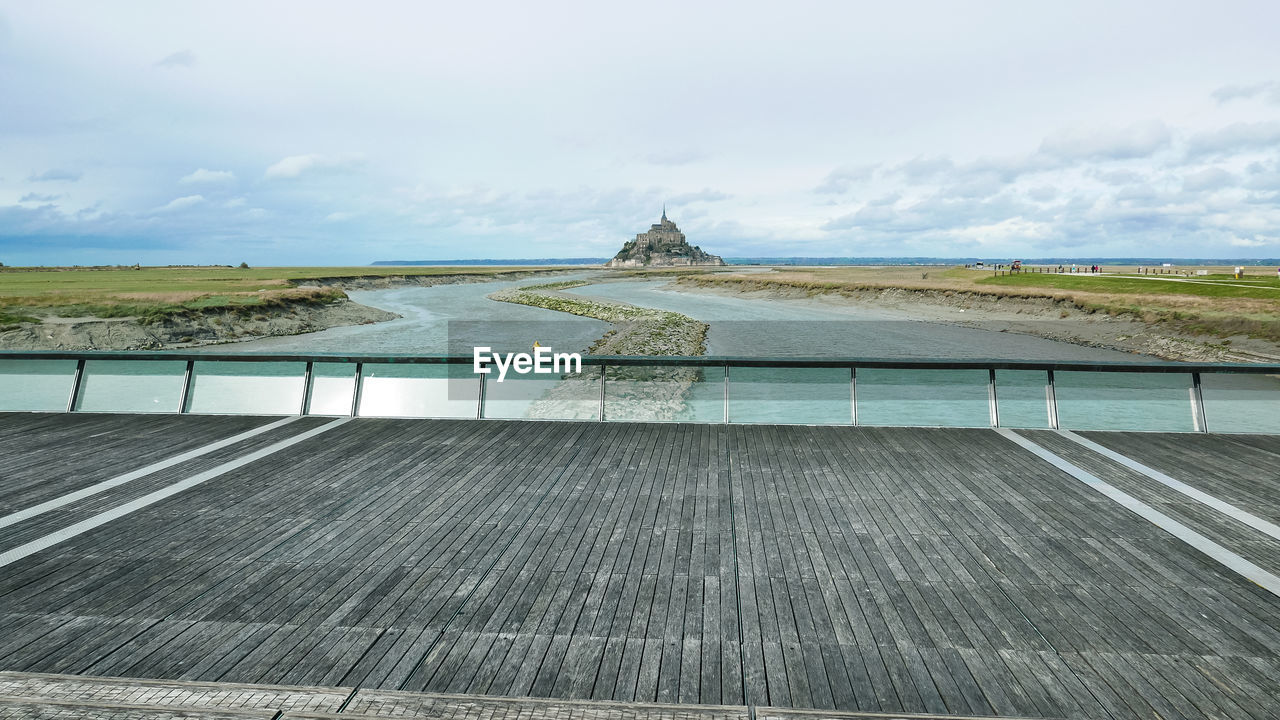 sky, walkway, water, cloud, nature, architecture, environment, sea, coast, day, built structure, no people, land, roof, travel destinations, travel, shore, scenics - nature, beauty in nature, environmental conservation, outdoors, landscape, boardwalk, renewable energy, horizon, tourism, ocean, tranquility, alternative energy