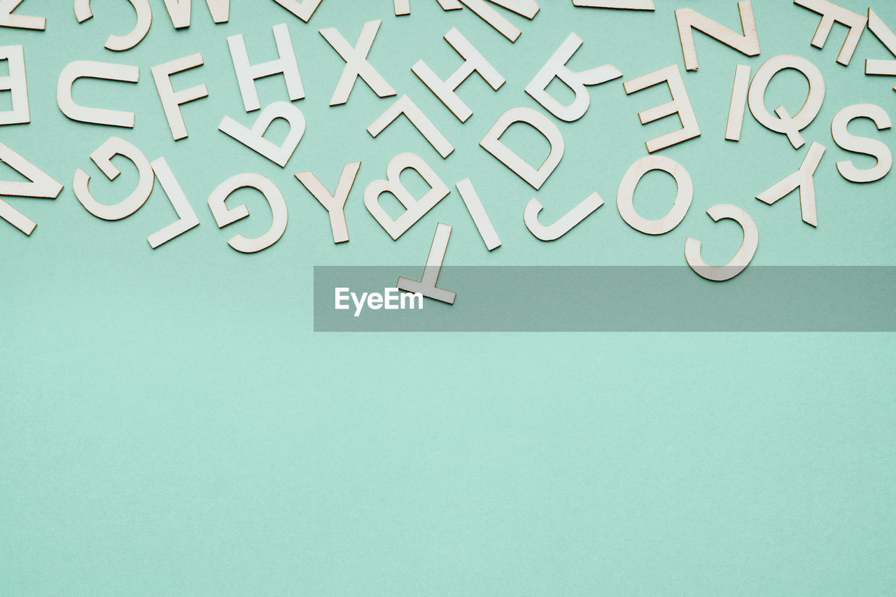 Jumble of wooden letters falling down on blue paper background