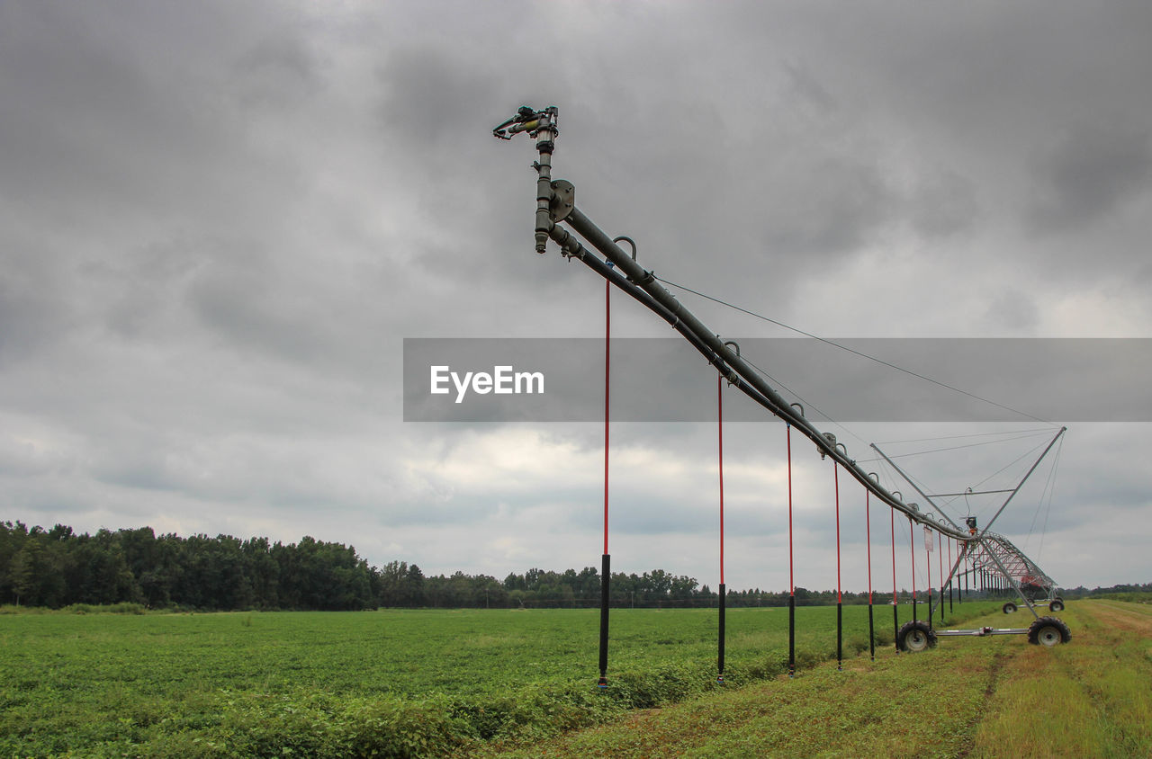 Wind turbines on field against sky