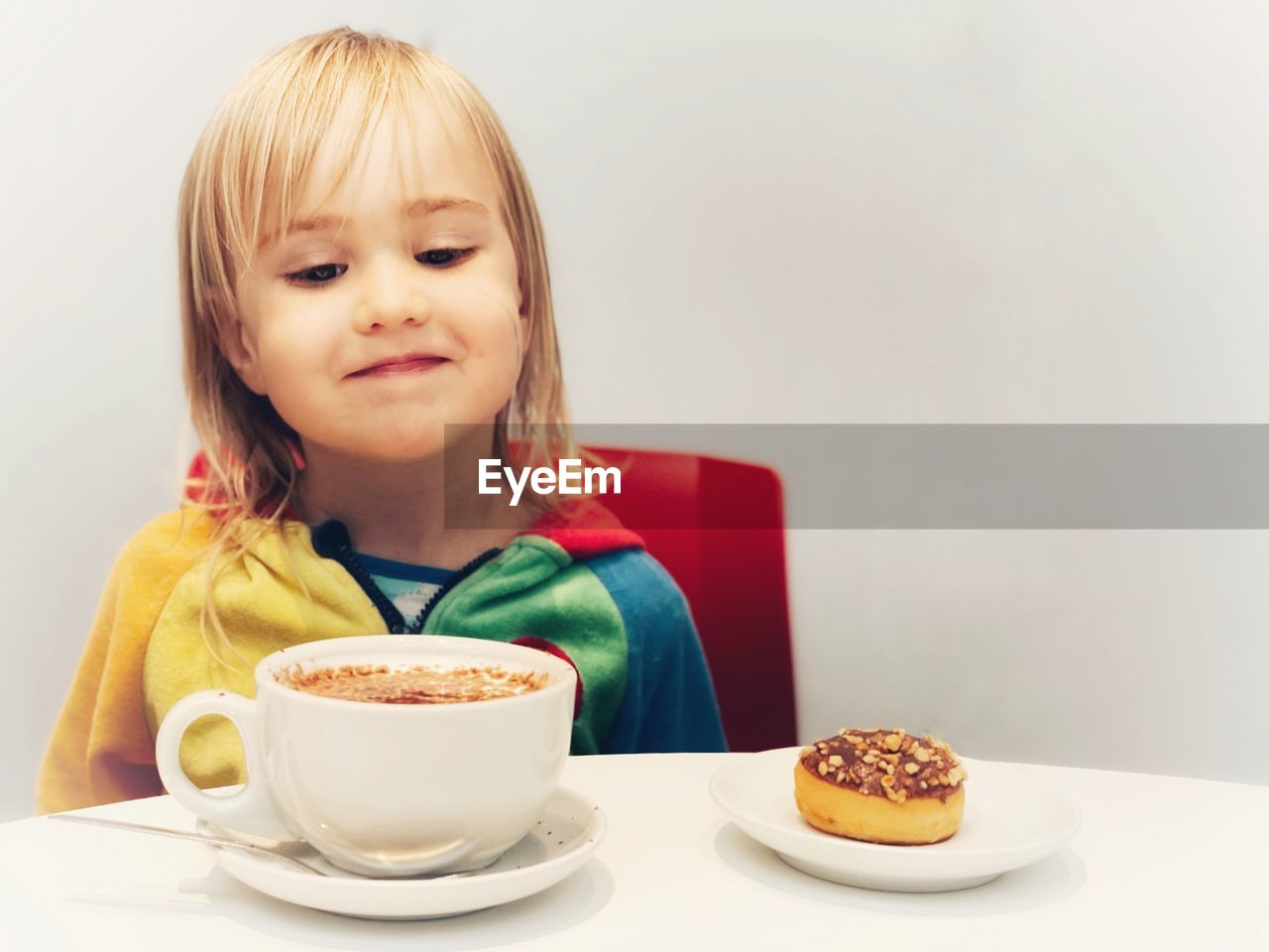 Portrait of child with coffee cup and cake