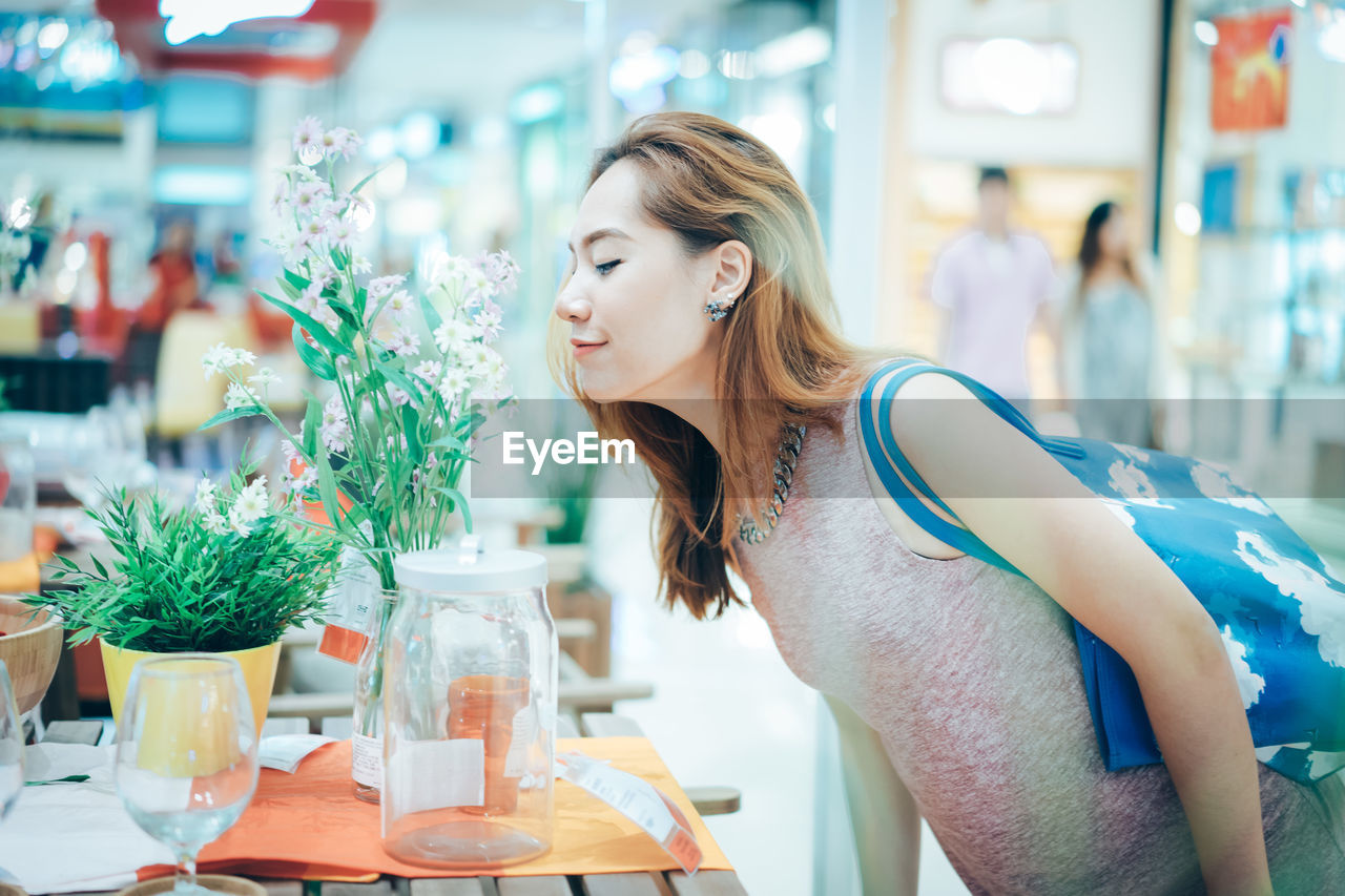 Woman smelling flowers in shopping mall