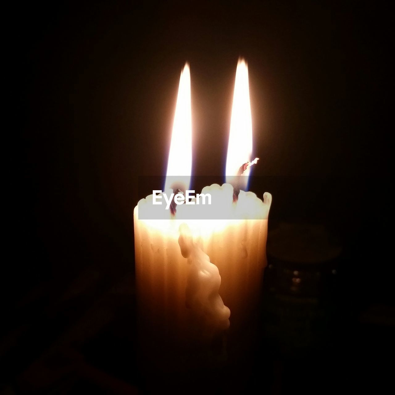 CLOSE-UP OF LIT CANDLES IN THE DARK