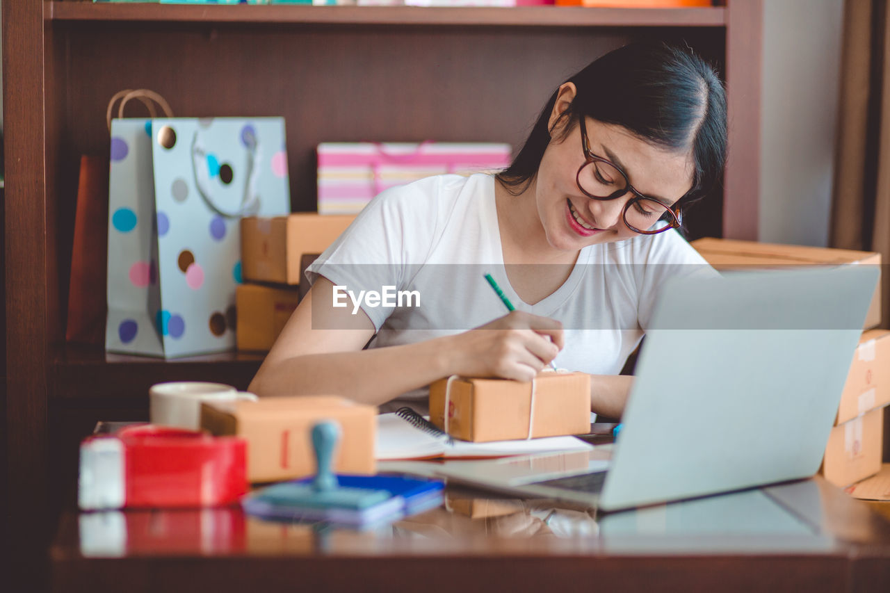 MIDSECTION OF WOMAN USING LAPTOP