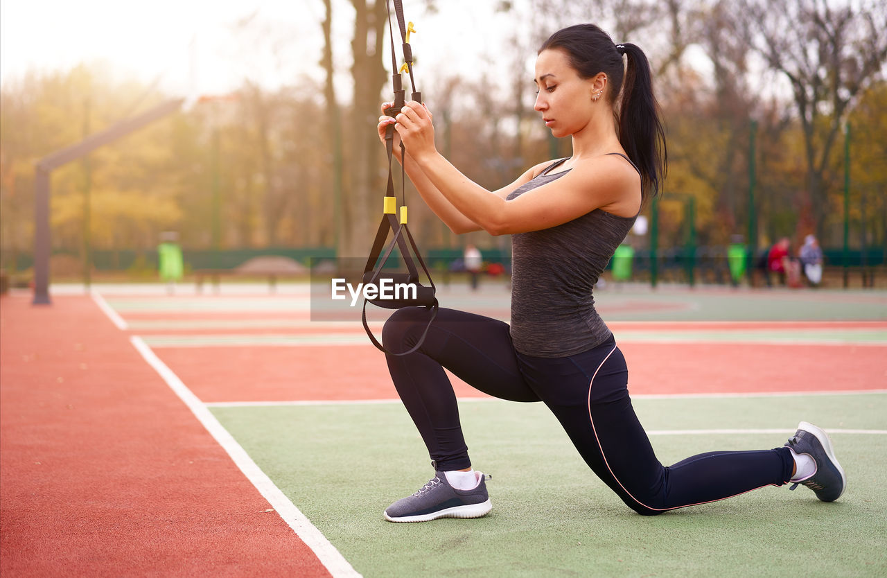 Full length of woman exercising on field