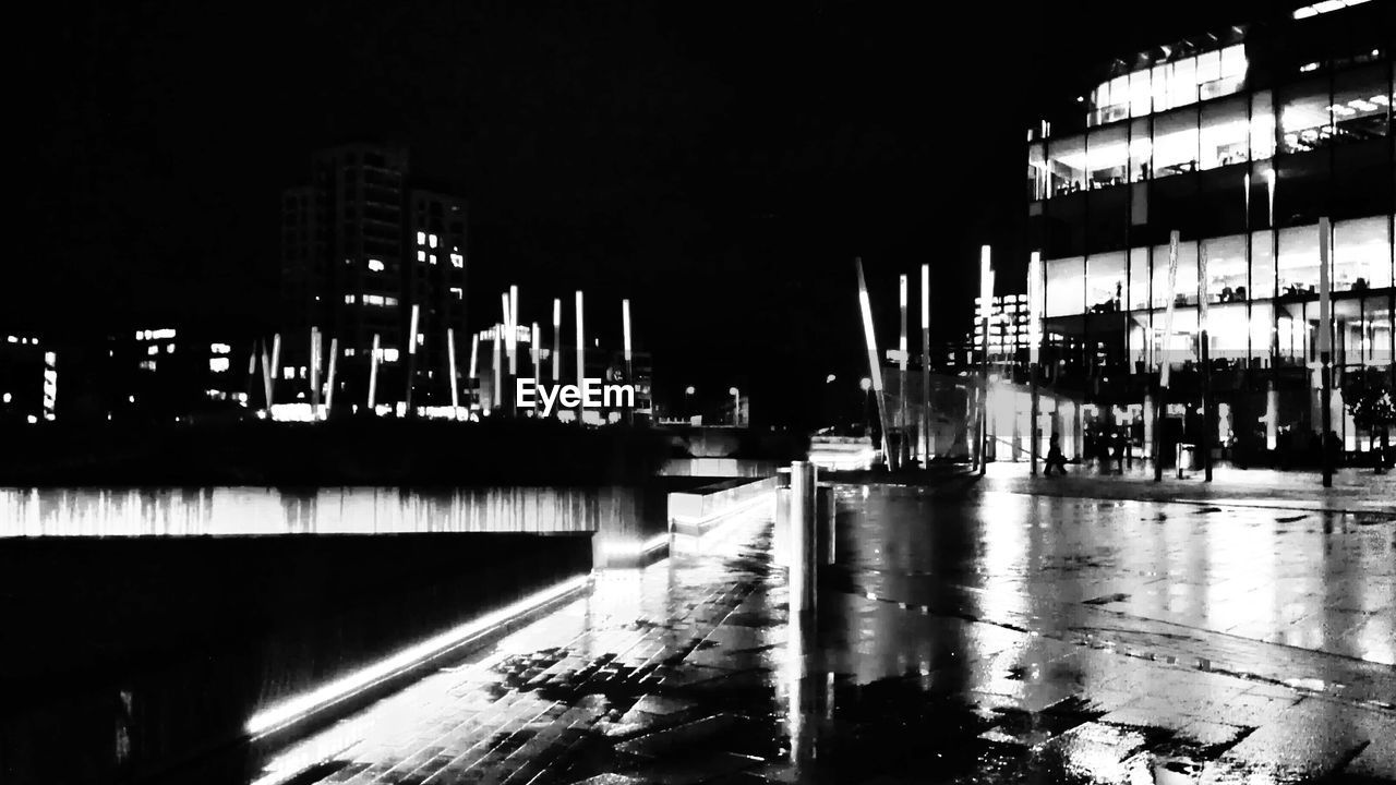 Illuminated buildings with wet street in grand canal square at night