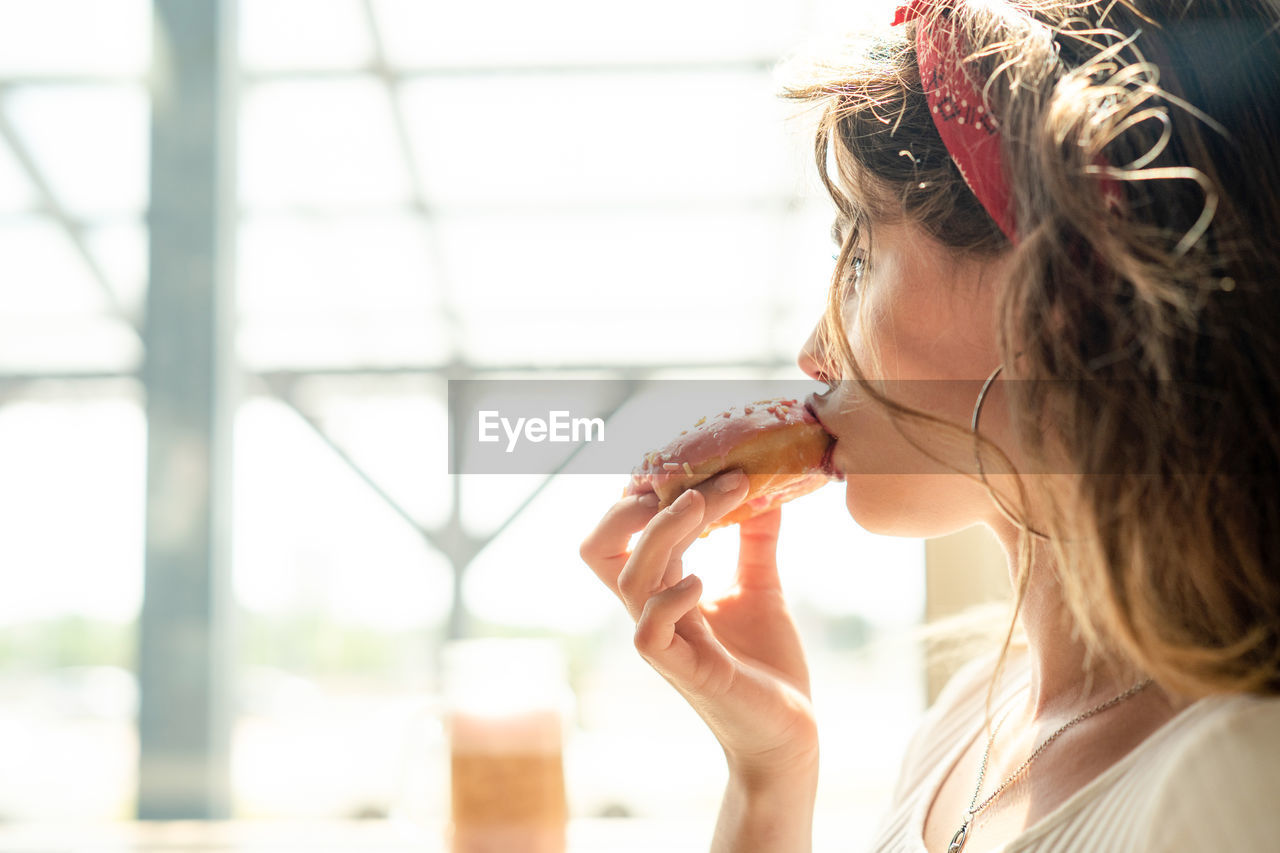 Young woman looking away while eating food