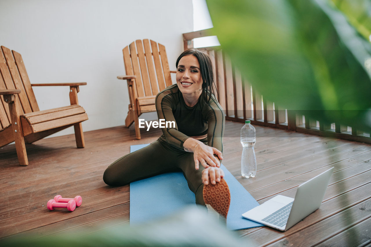 Young woman using phone while sitting on table