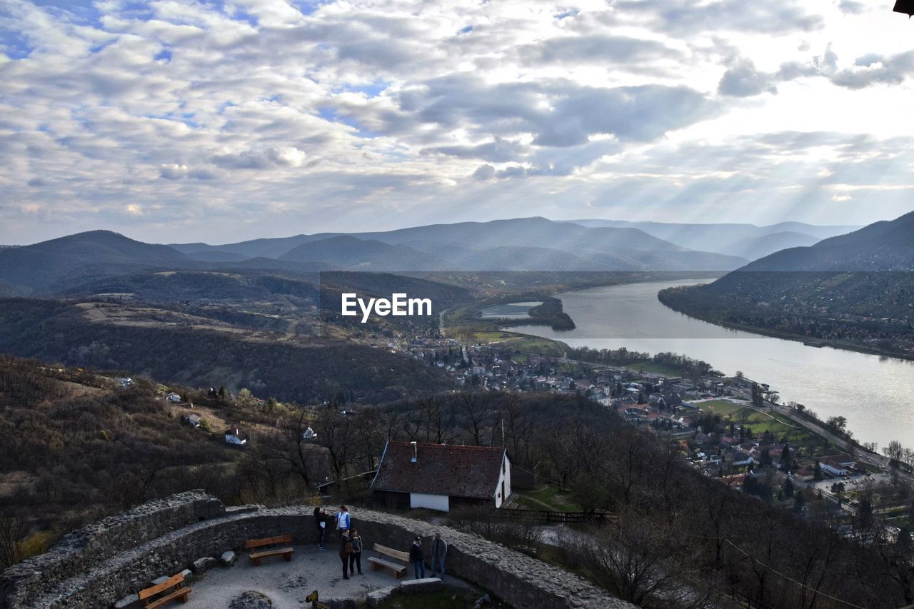 High angle view of river and mountains against cloudy sky