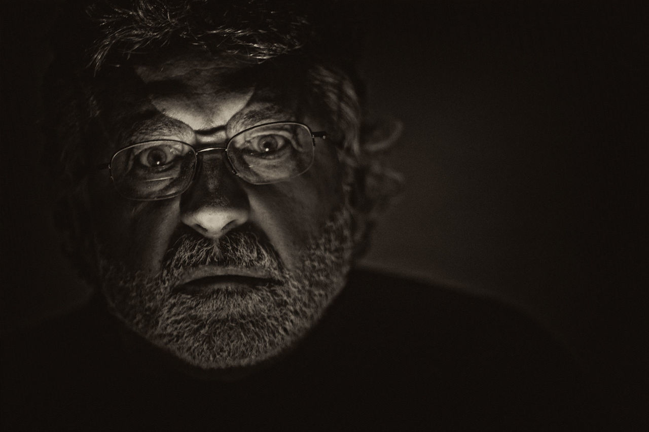 Close-up portrait of man in darkroom