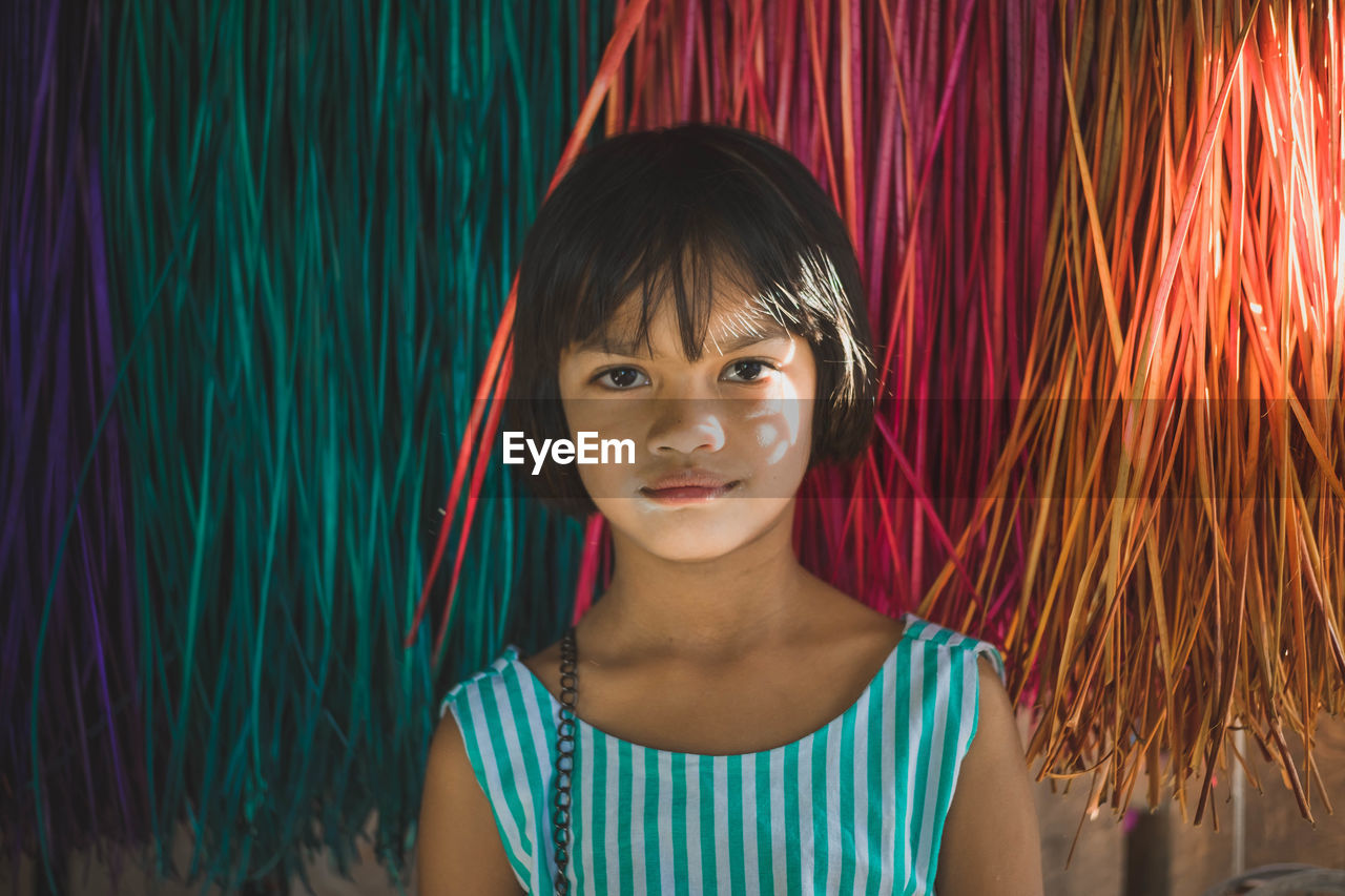 Portrait of smiling girl by curtain