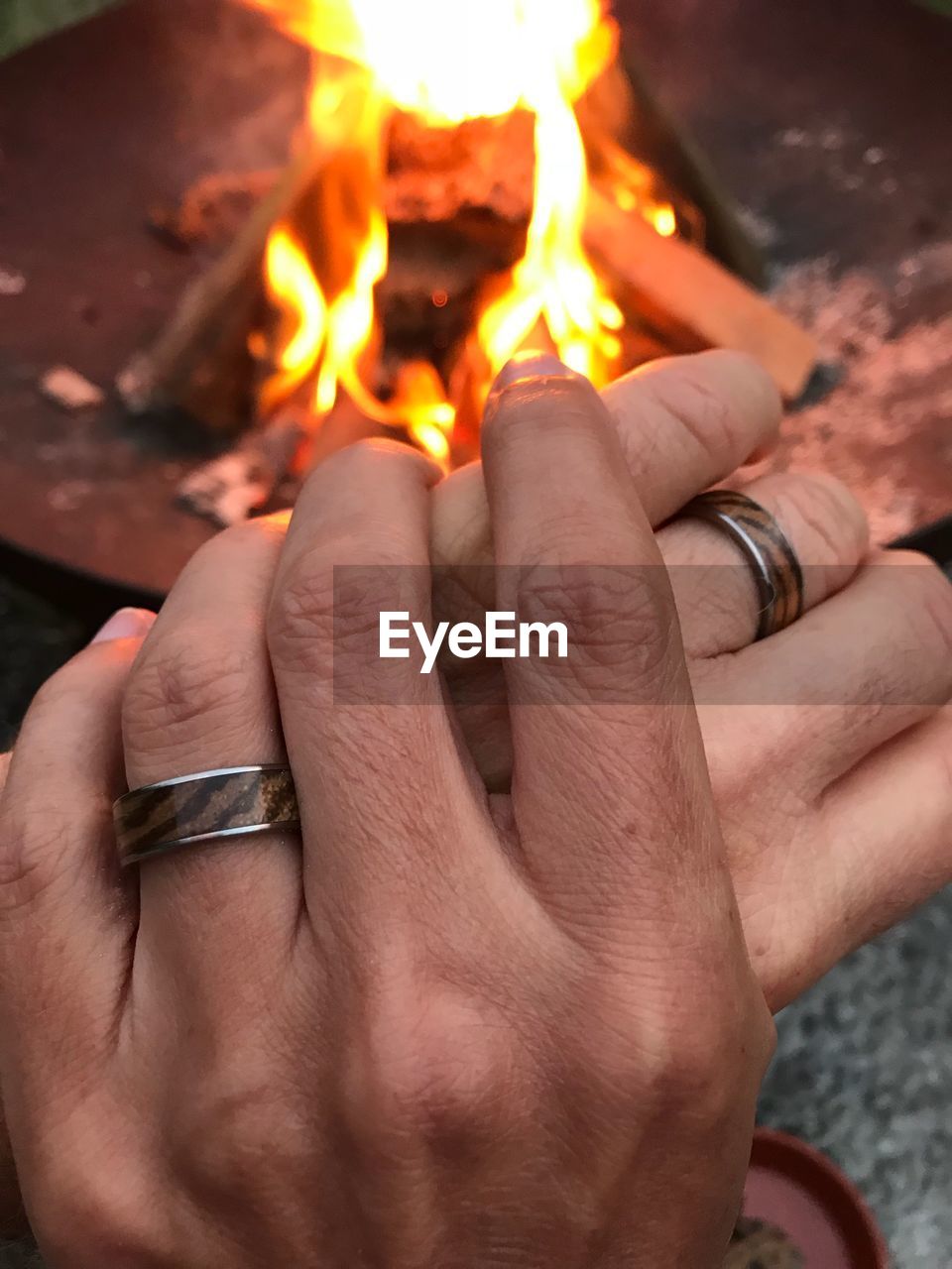 CLOSE-UP OF HAND HOLDING BURNING CANDLE