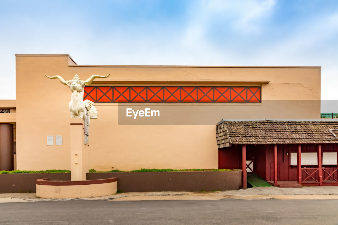 EXTERIOR OF TRADITIONAL BUILDING BY HOUSE AGAINST SKY