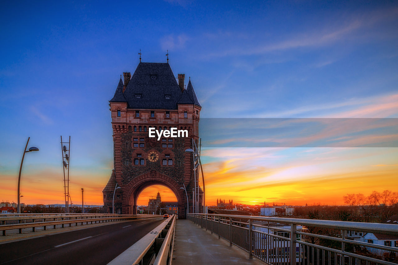 View of bridge and buildings against sky during sunset