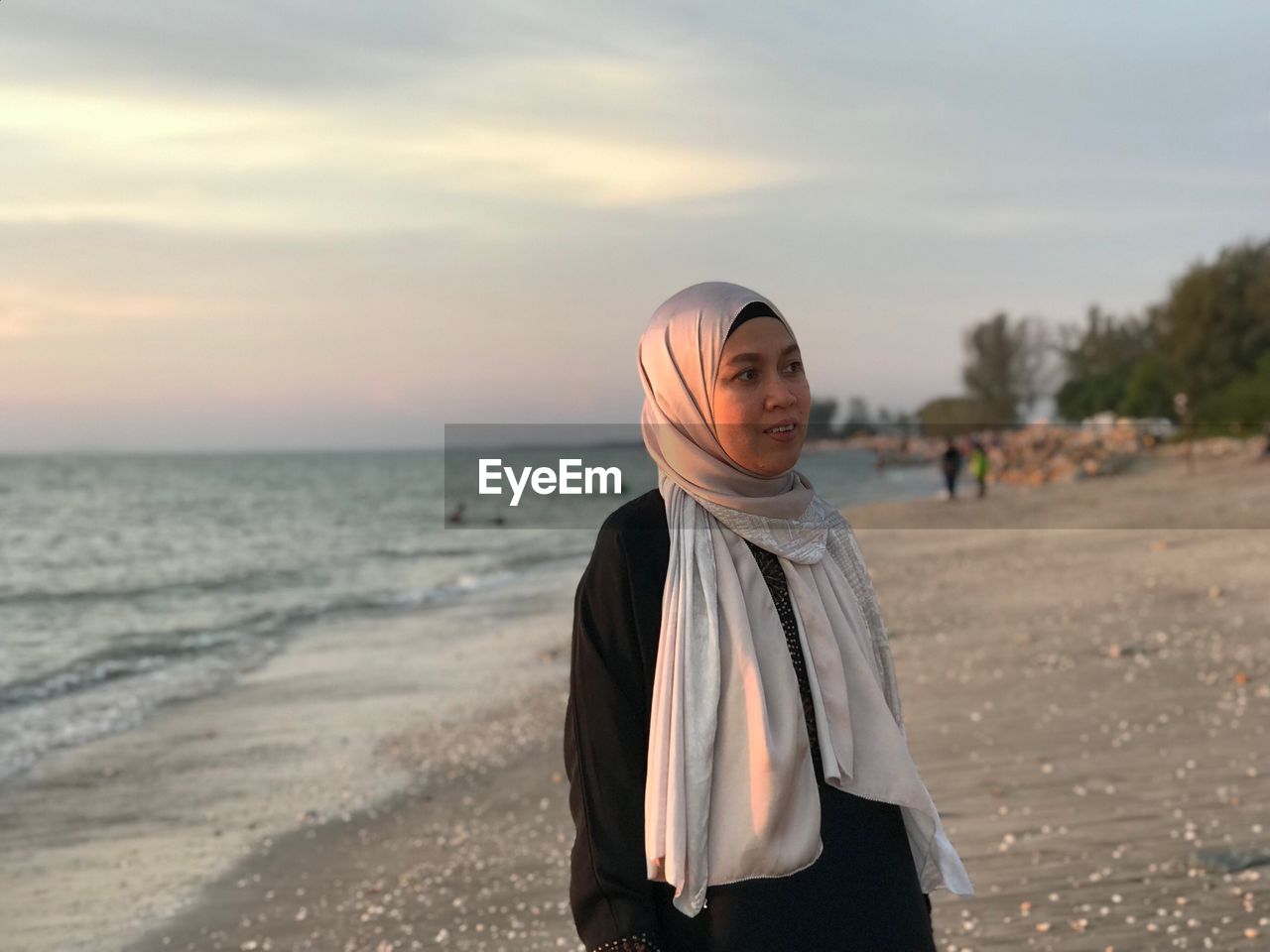 Mature woman wearing hijab standing at beach