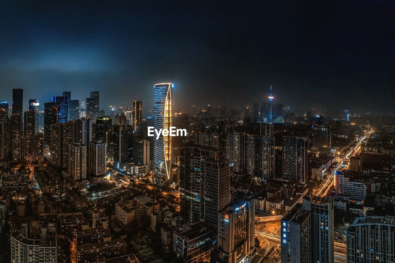 Illuminated cityscape against sky at night