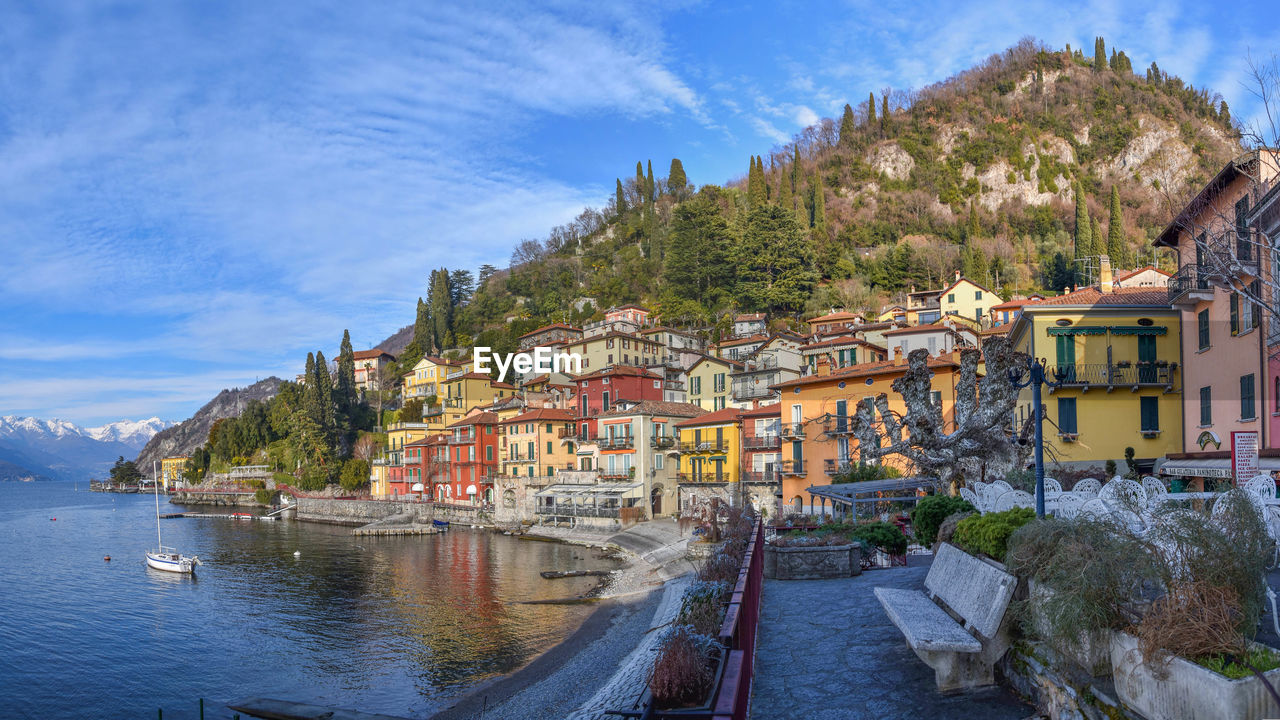 Houses by lake against sky in city