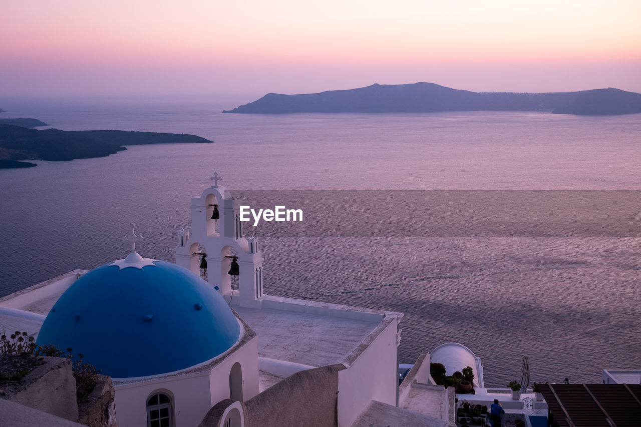 High angle view of sea and buildings against sky during sunset