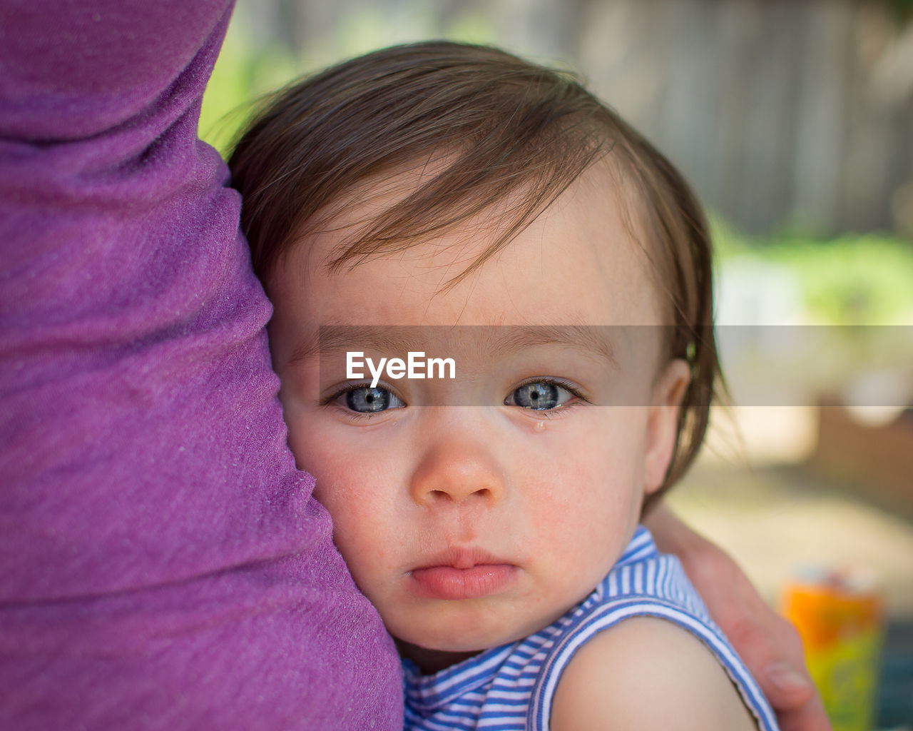 Close-up portrait of cute crying girl embracing mother