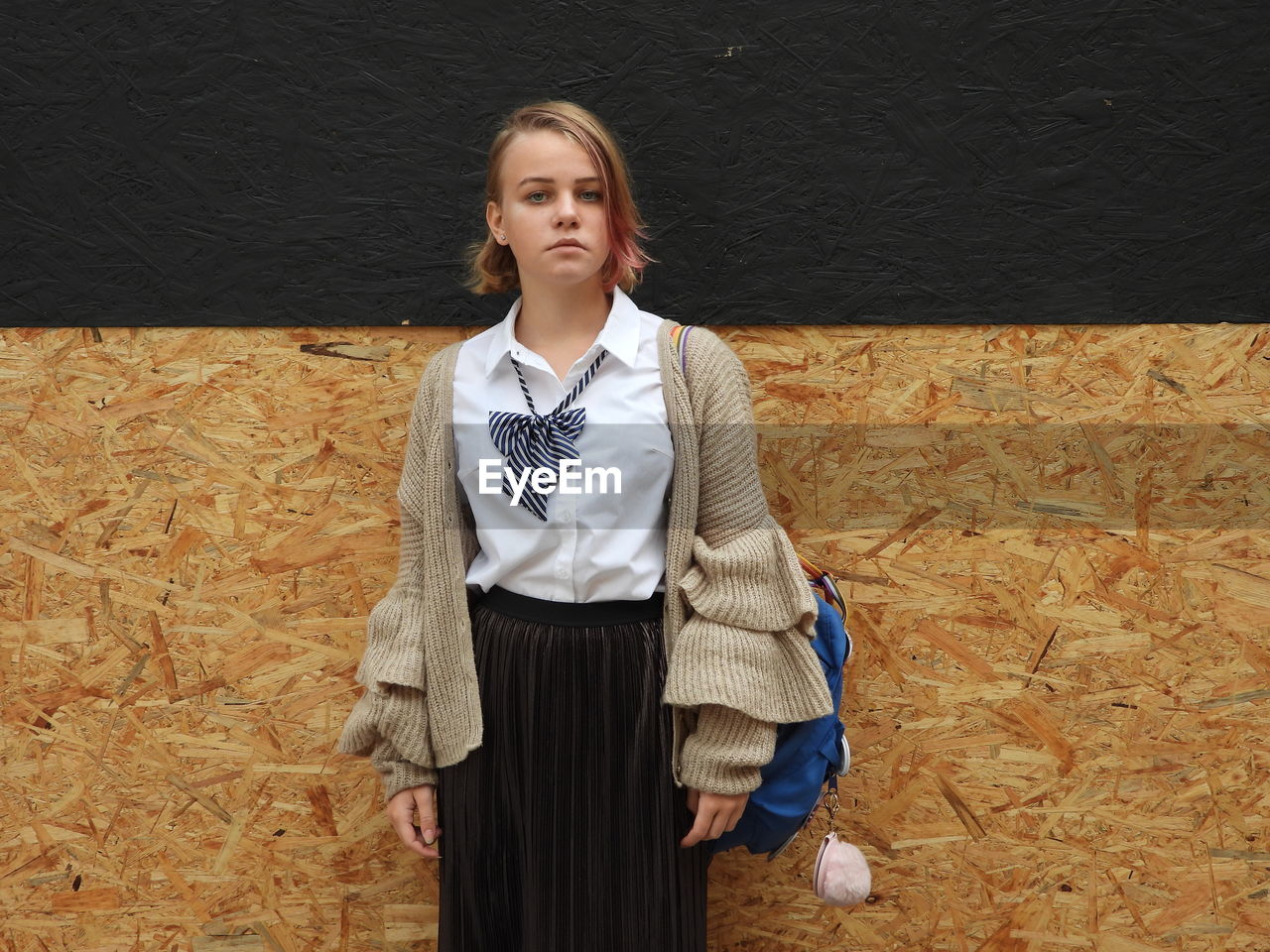 Portrait of girl standing against wall