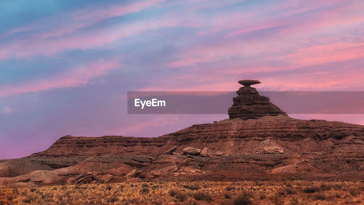 Rock formations on landscape against sky during sunset