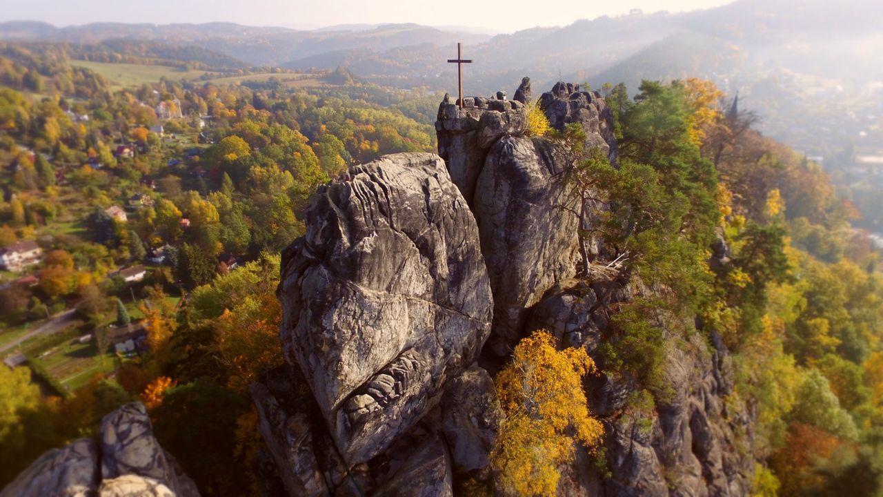 Cross on rock surrounded by autumn trees