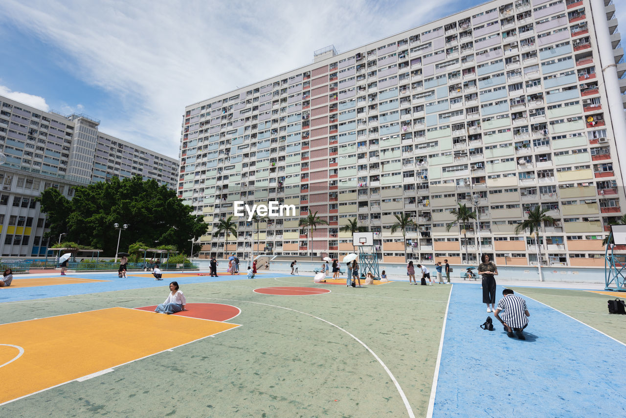 People in playground by buildings in city