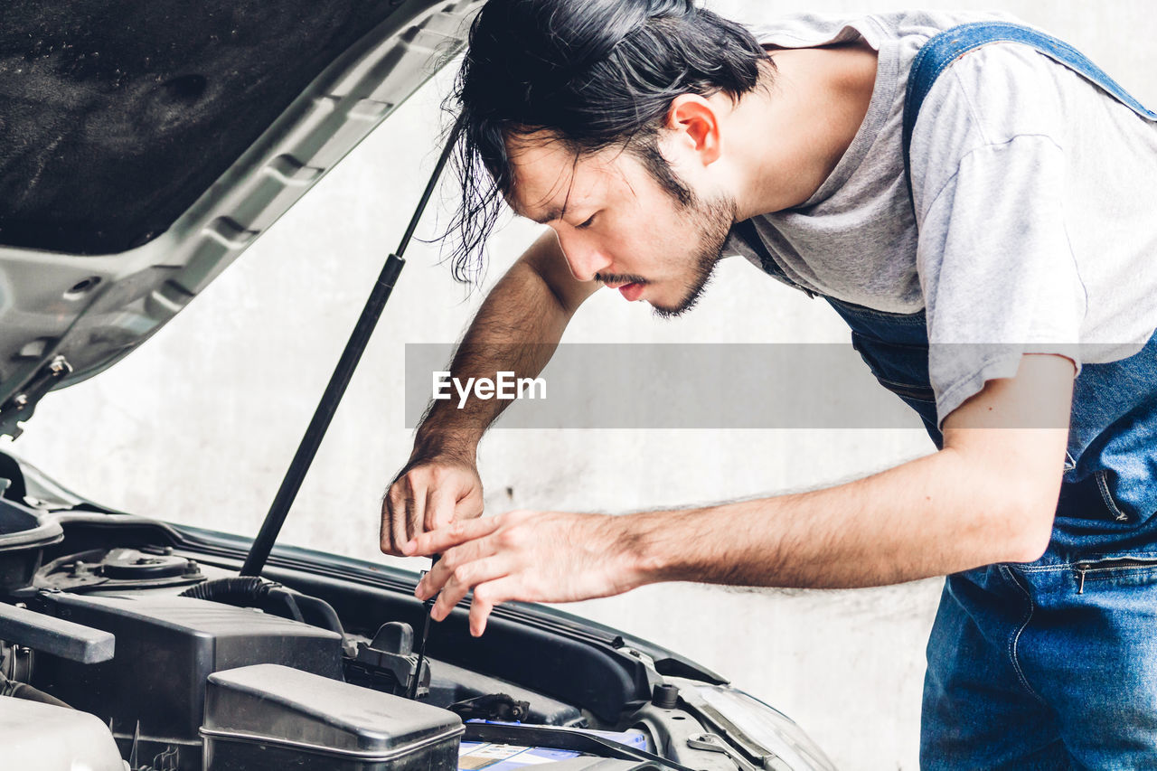 Man repairing car outdoors