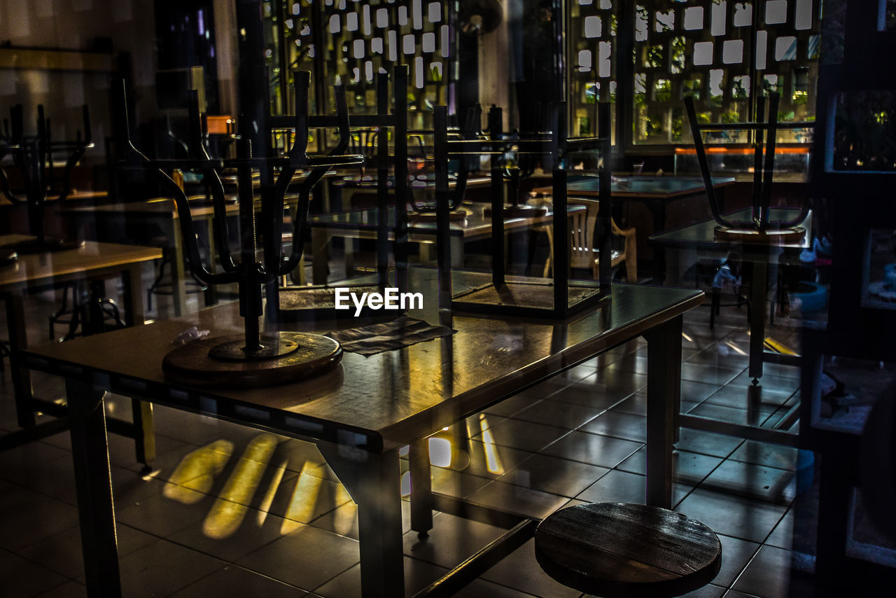 Empty chairs and table in restaurant at night